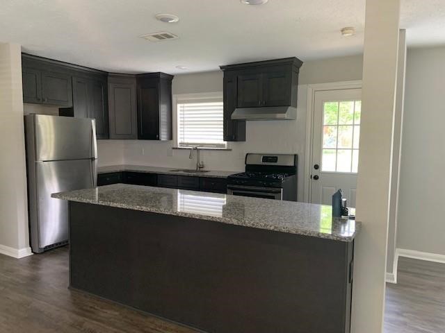 1000 Thomas Avenue Conroe, TX 77301 - Photo 12 of 20 a kitchen with granite countertop a refrigerator and a sink