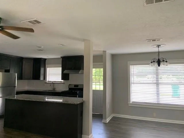 a kitchen with kitchen island a sink stainless steel appliances and cabinets