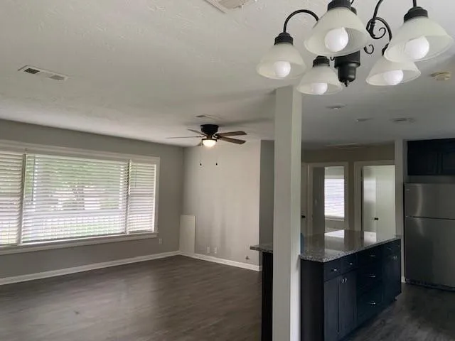 a view of a hallway with a chandelier fan and windows