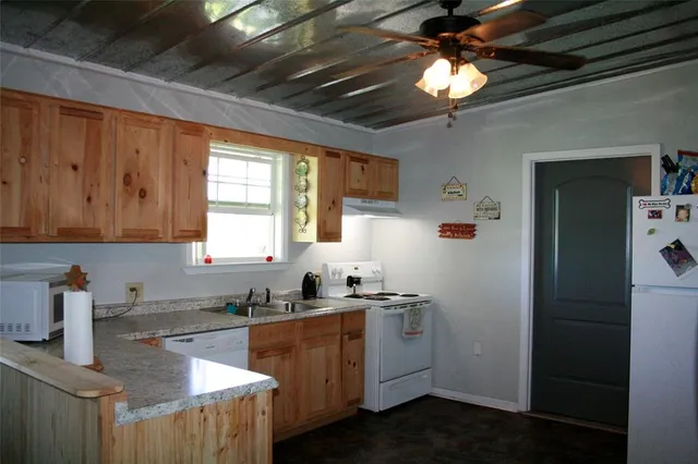 a kitchen with stainless steel appliances granite countertop a refrigerator a sink and a stove