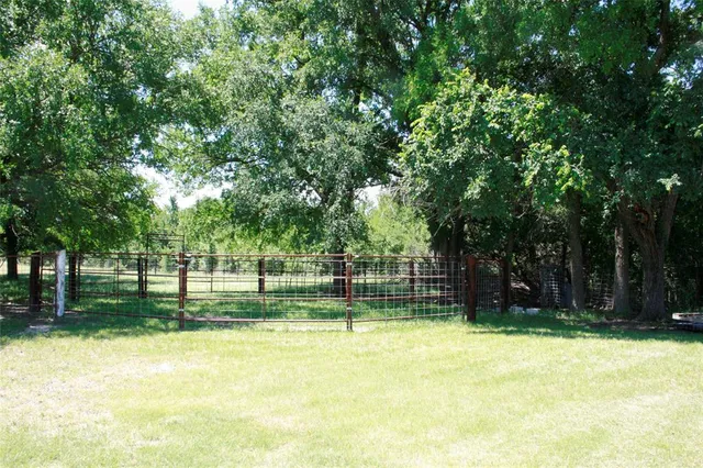 a view of a swimming pool with a patio and backyard