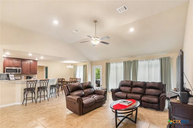 a living room with furniture and a view of kitchen