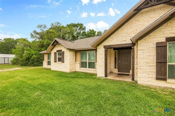 a view of a house with a backyard