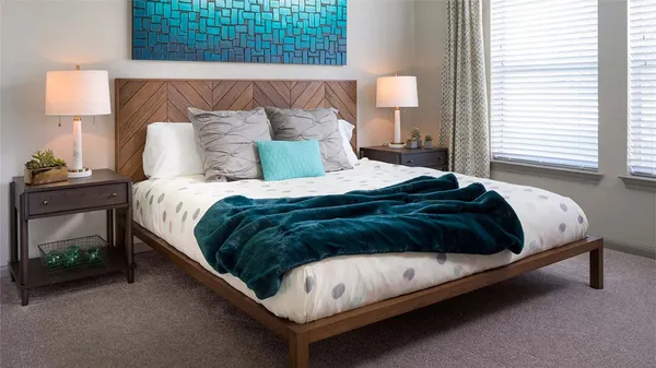 a bedroom with a bed lamp and a window