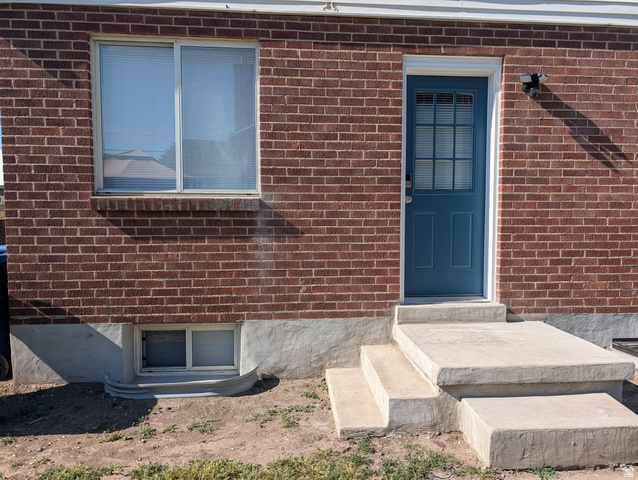 2880 Merton Way Magna, UT 84044 - Photo 24 of 30 Red brick exterior featuring a blue paneled door with lites