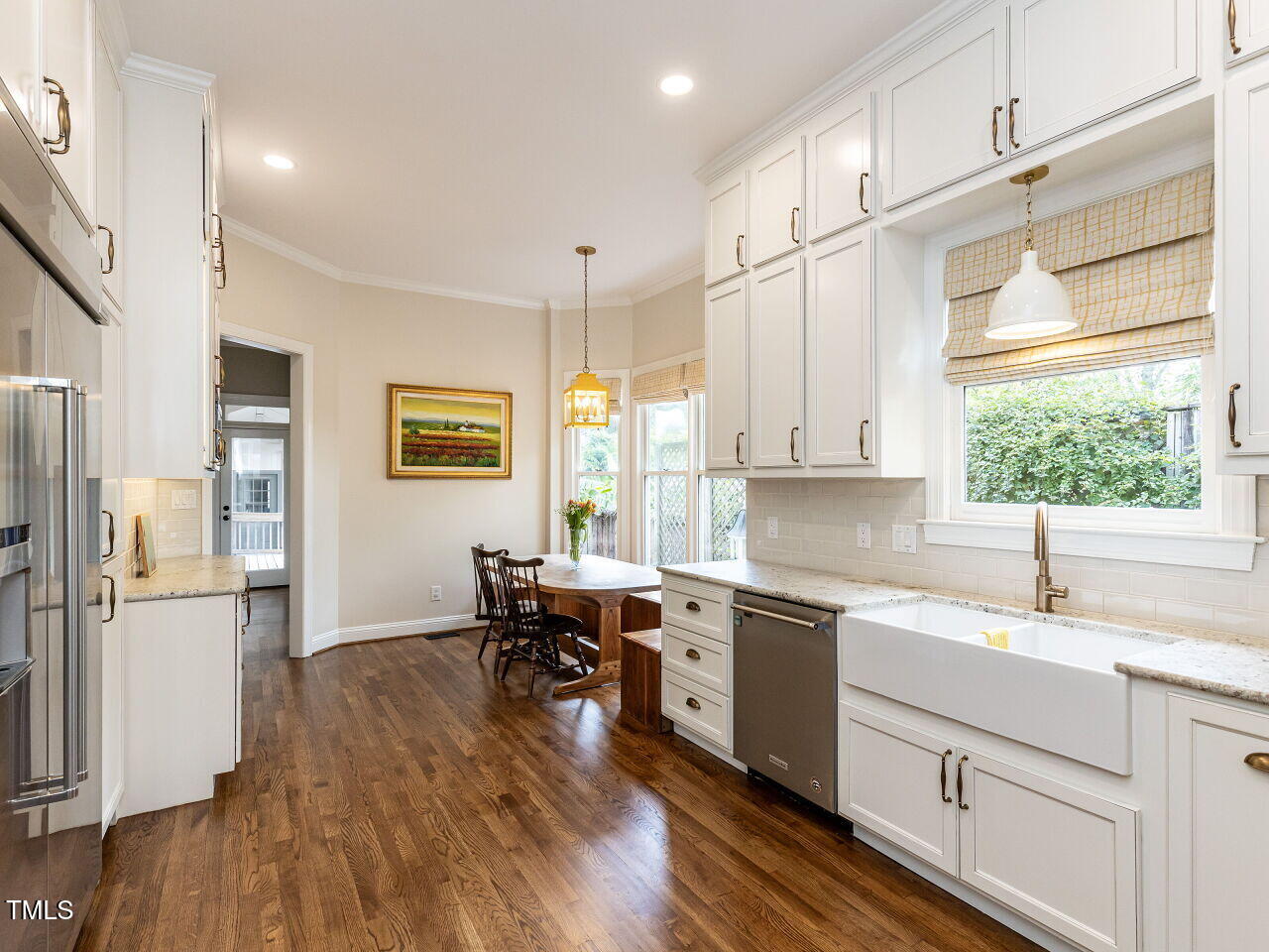 3108 Agecroft Road Raleigh, NC 27608 - Photo 5 of 42 a kitchen with granite countertop a refrigerator a sink dishwasher and white cabinets with wooden floor