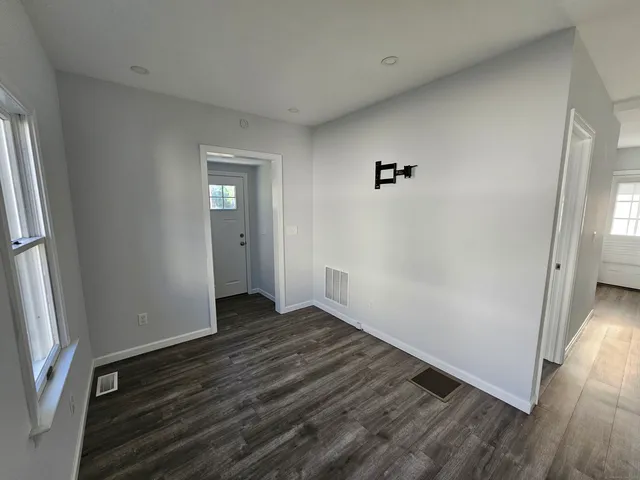 an empty room with wooden floor and a window
