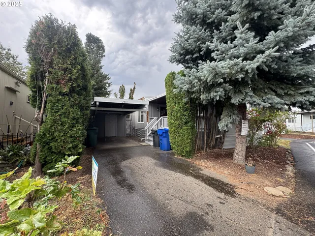 a view of a small house with a tree and a yard