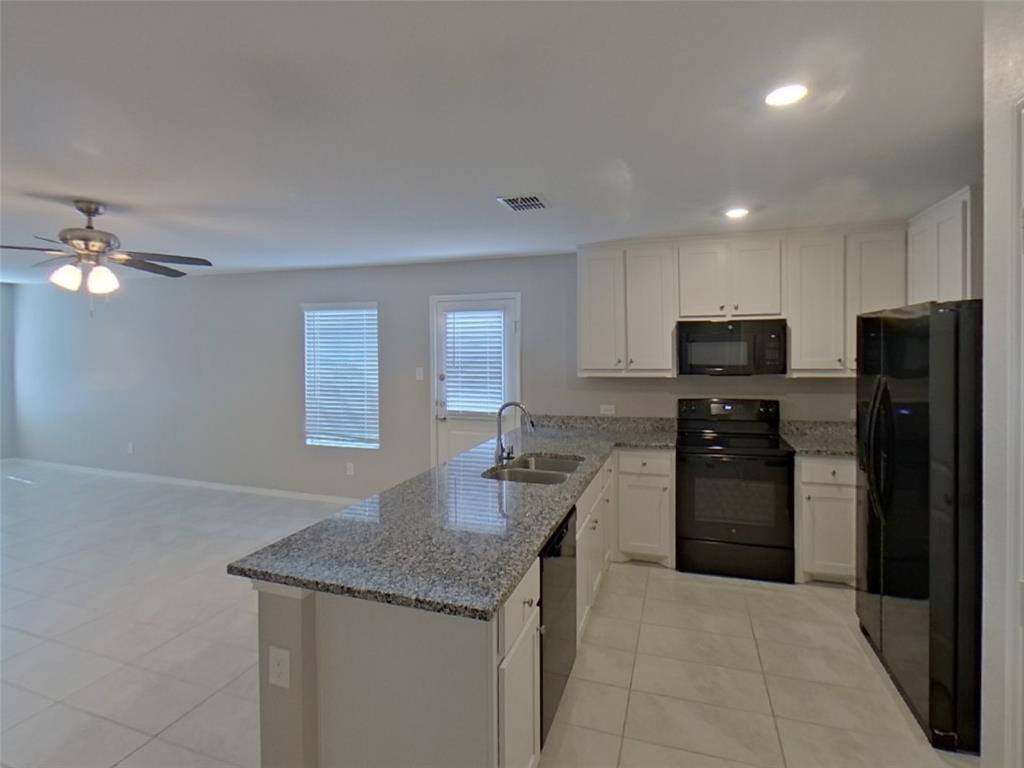 116 Cornstalk Lane Princeton, TX 75407 - Photo 5 of 17 a kitchen with kitchen island granite countertop stainless steel appliances a sink stove refrigerator and cabinets