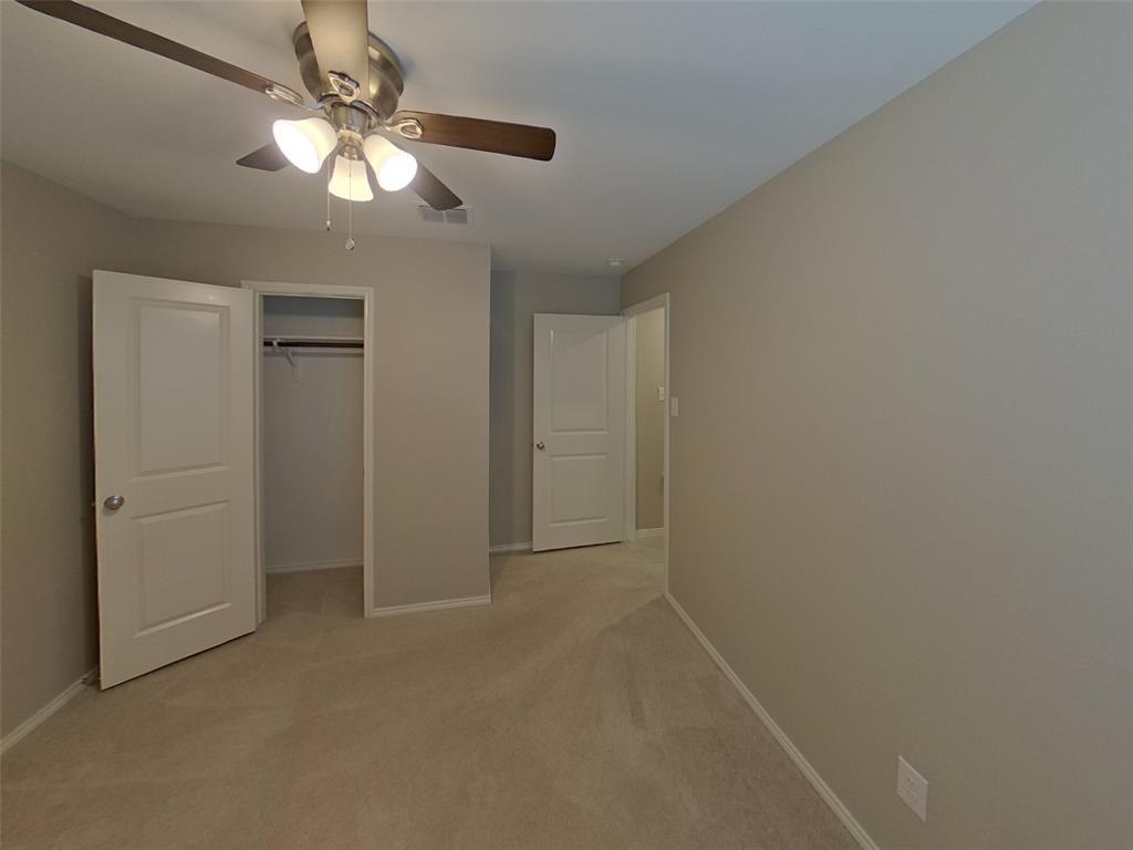 116 Cornstalk Lane Princeton, TX 75407 - Photo 10 of 17 an empty room with a chandelier fan and closet area