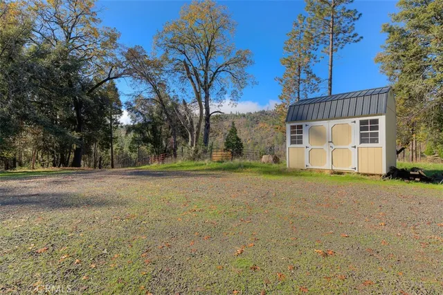 a view of a house with backyard and trees