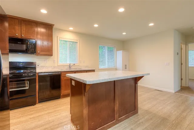 a kitchen with stainless steel appliances granite countertop a stove a sink and a microwave