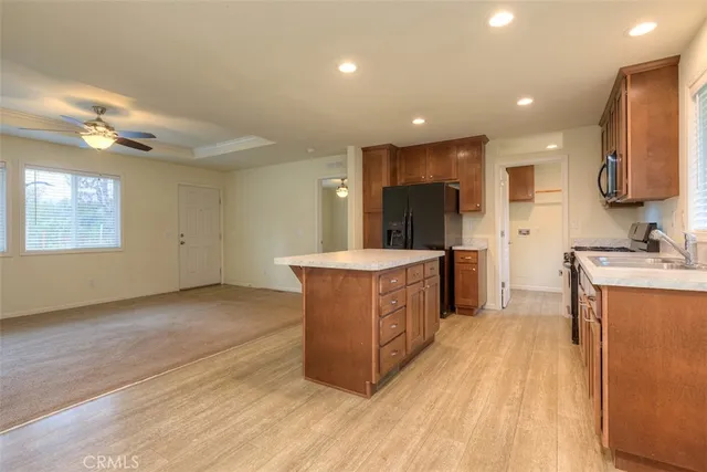 a large kitchen with stainless steel appliances a large counter top a stove and a sink