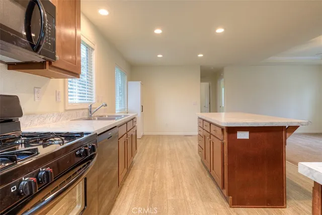 a kitchen with stainless steel appliances granite countertop a stove a sink and a microwave