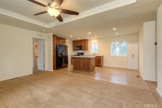 a view of a kitchen with a stove cabinets a ceiling fan and wooden floor