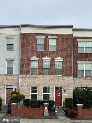 a front view of a house with lots of windows and plants