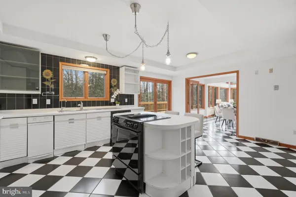 a kitchen with a checkered floor and white cabinets