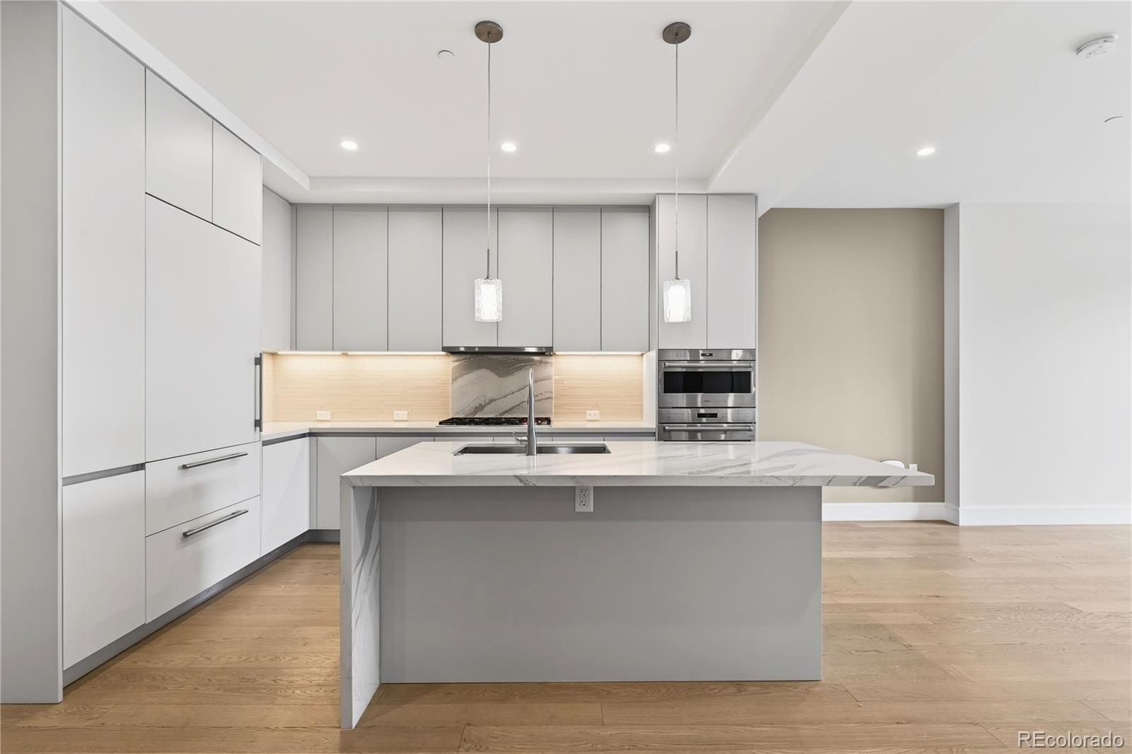 1901 Wazee Street, Unit 515 Denver, CO 80202 - Photo 11 of 46 a kitchen with stainless steel appliances granite countertop a stove top oven a sink a refrigerator and white cabinets