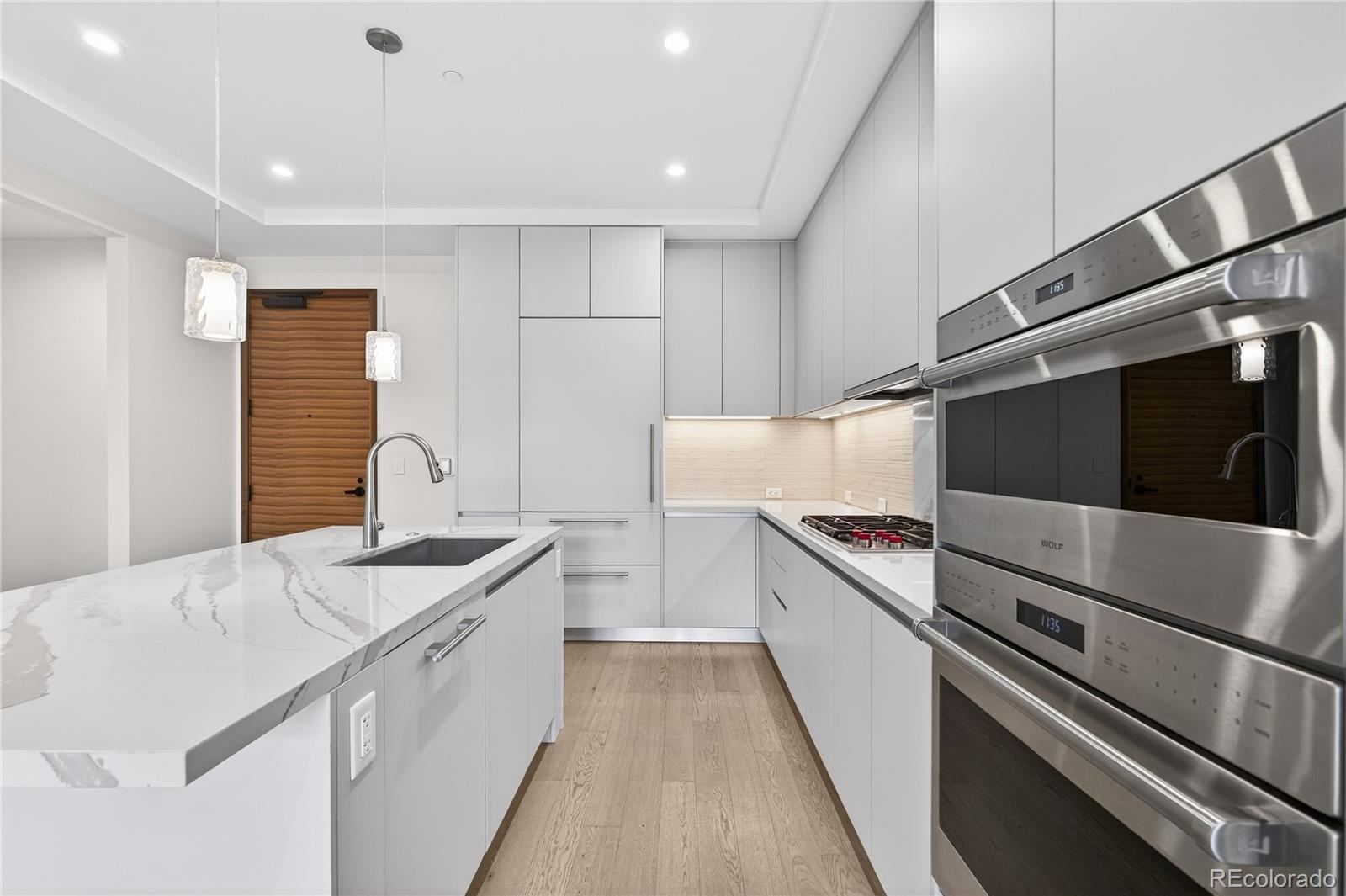 1901 Wazee Street, Unit 515 Denver, CO 80202 - Photo 14 of 46 a kitchen with granite countertop white cabinets and white appliances
