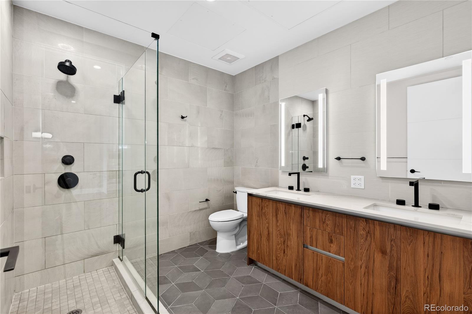 1901 Wazee Street, Unit 515 Denver, CO 80202 - Photo 28 of 46 a bathroom with a double vanity sink toilet and shower