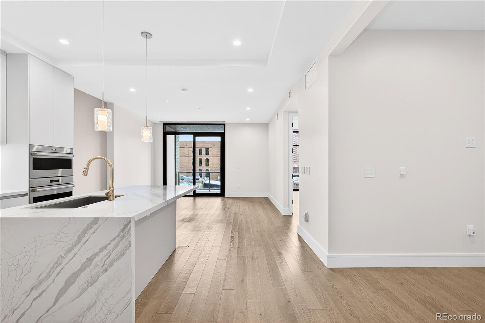 1901 Wazee Street, Unit 515 Denver, CO 80202 - Photo 6 of 46 a large kitchen with a lot of cabinets and wooden floor