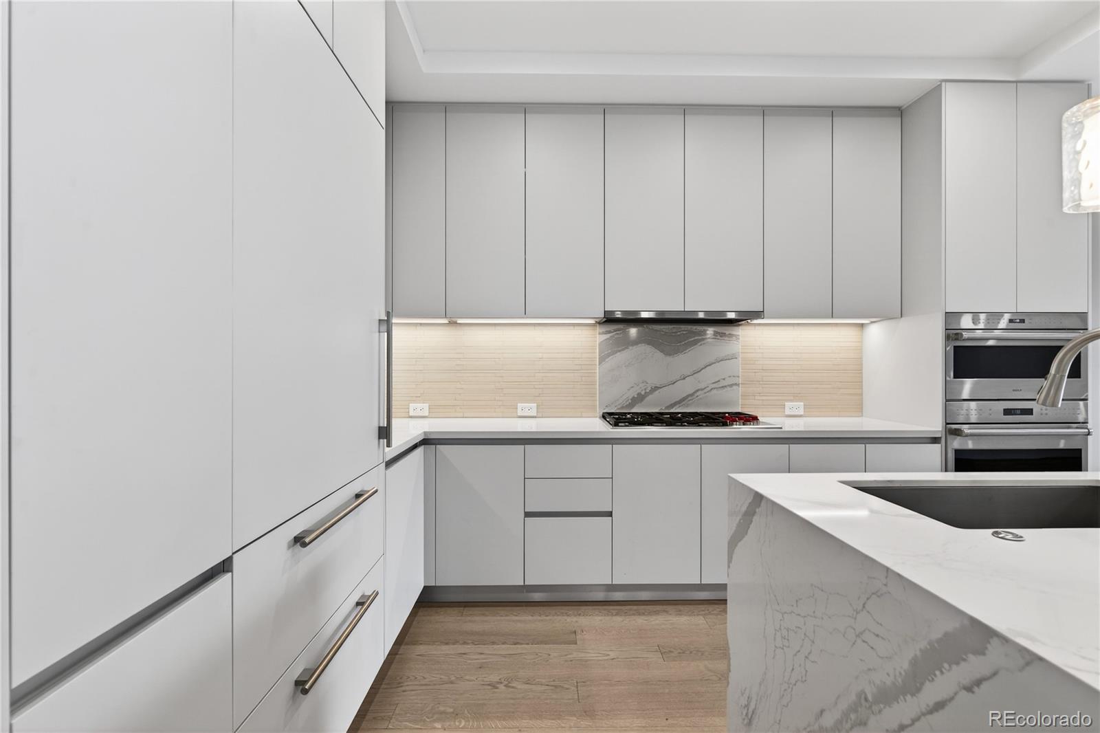1901 Wazee Street, Unit 515 Denver, CO 80202 - Photo 7 of 46 a kitchen with granite countertop white cabinets and stainless steel appliances