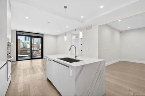 a kitchen with stainless steel appliances granite countertop a stove top oven a sink a refrigerator and white cabinets