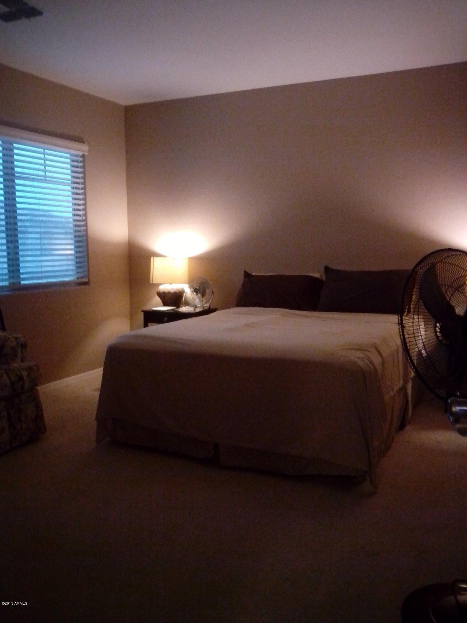 9427 West Monte Vista Road Phoenix, AZ 85037 - Photo 9 of 13 a bedroom with a bed and a night stand