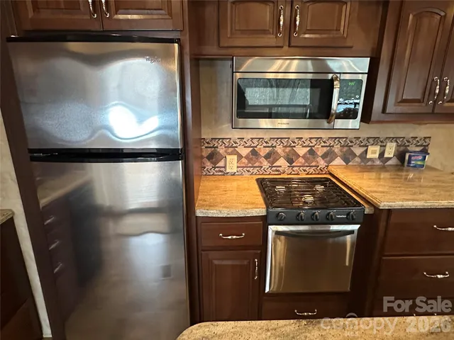 a kitchen with granite countertop a sink stove and cabinets