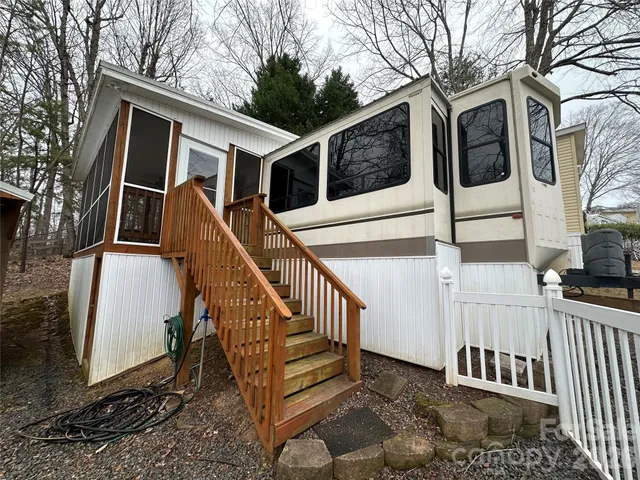 a view of a wooden house with a large tree