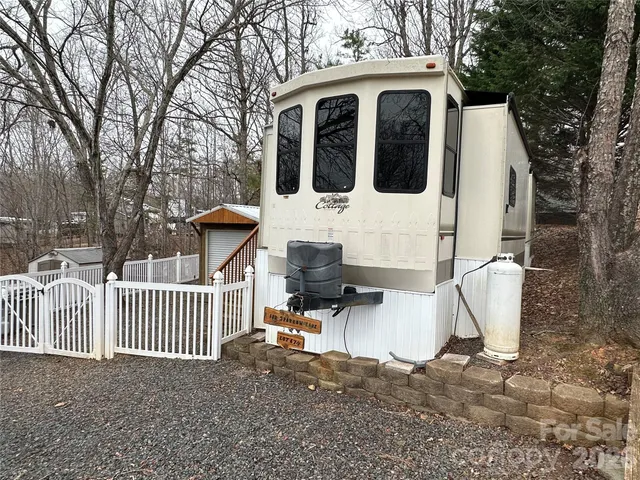a view of a house with a yard and large tree