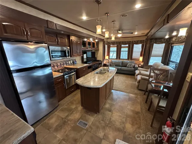 a room with lots of appliances and a view of living room