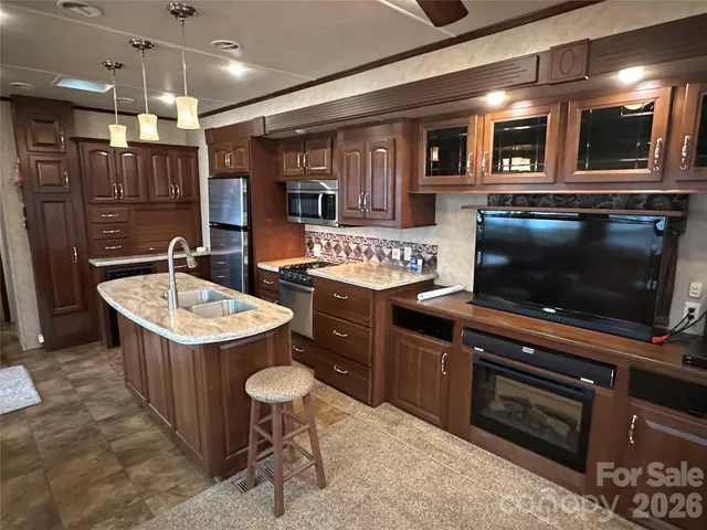 a kitchen with stainless steel appliances granite countertop a sink stove and cabinets