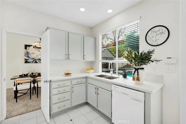 a kitchen with a sink a clock and cabinets