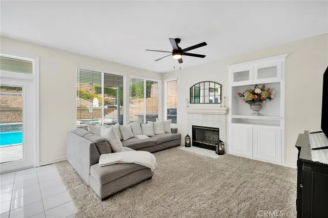a living room with furniture a fireplace and a large window