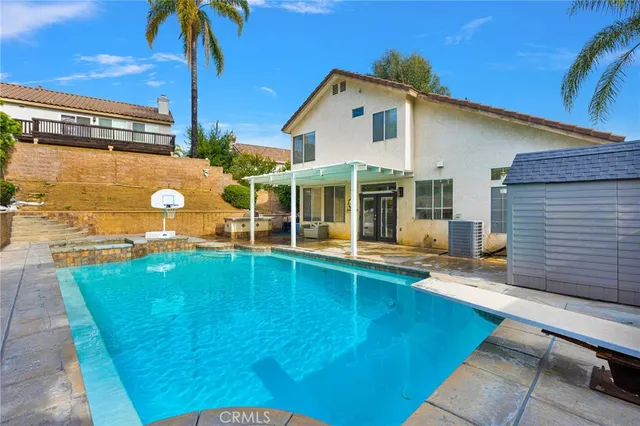 a view of a house with pool and a yard