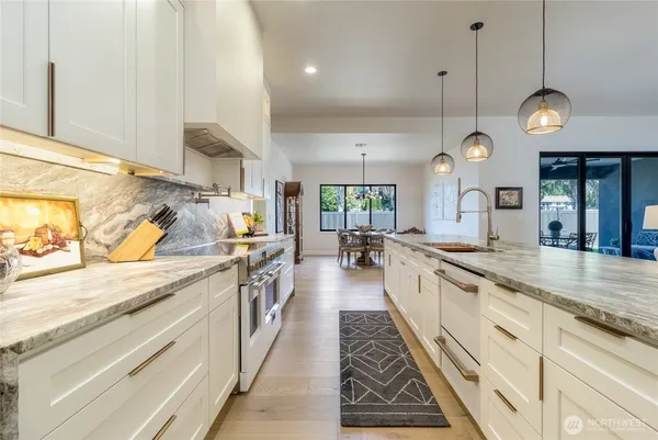 a large kitchen with kitchen island granite countertop a large center island and a view of living room