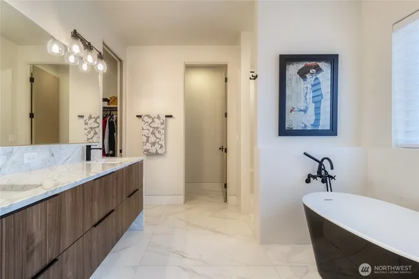 a bathroom with a double vanity sink mirror and bathtub