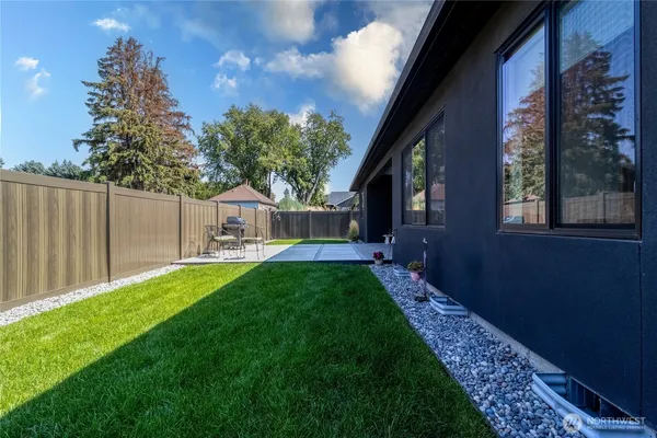 a view of a house with backyard and a tree