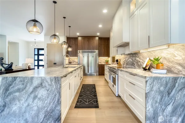 a large kitchen with stainless steel appliances kitchen island granite countertop a large counter top and wooden floors