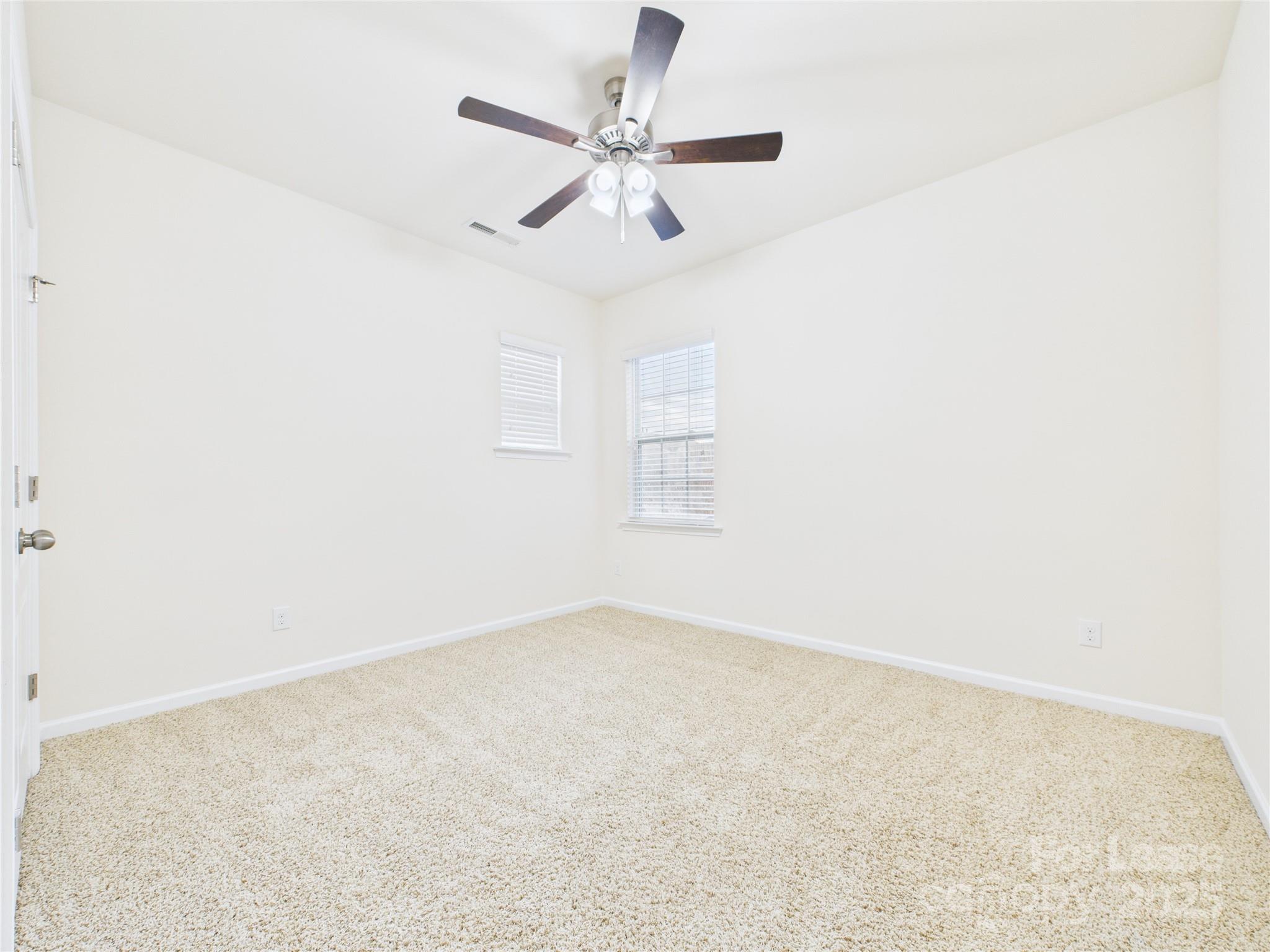 1249 Reflection Avenue Northwest Concord, NC 28027 - Photo 11 of 25 an empty room with ceiling fan and window