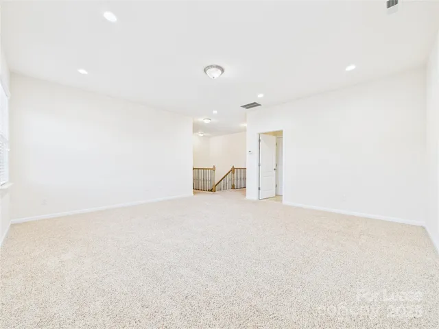 an empty room with a chandelier fan