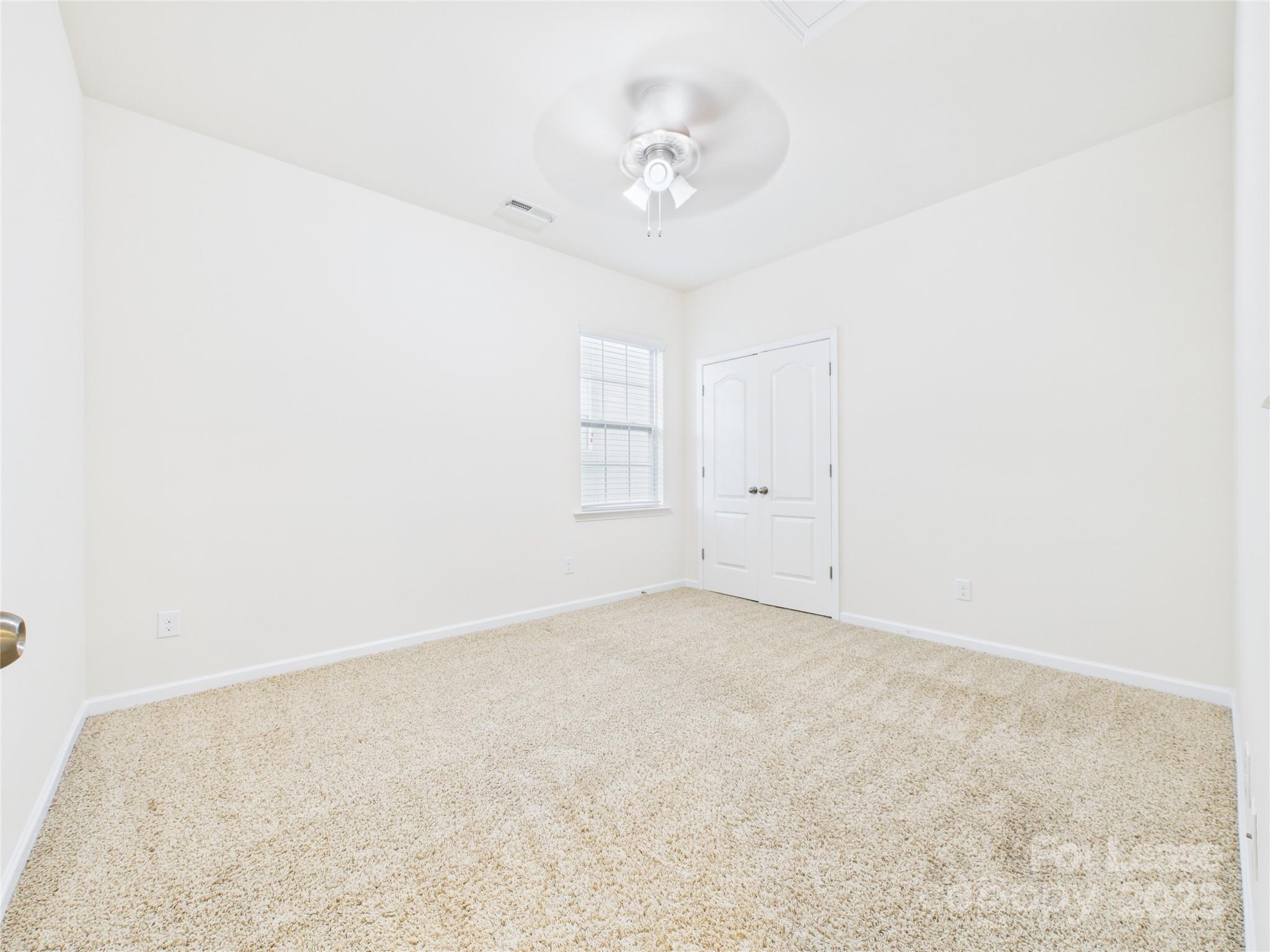 1249 Reflection Avenue Northwest Concord, NC 28027 - Photo 15 of 25 an empty room with a chandelier fan