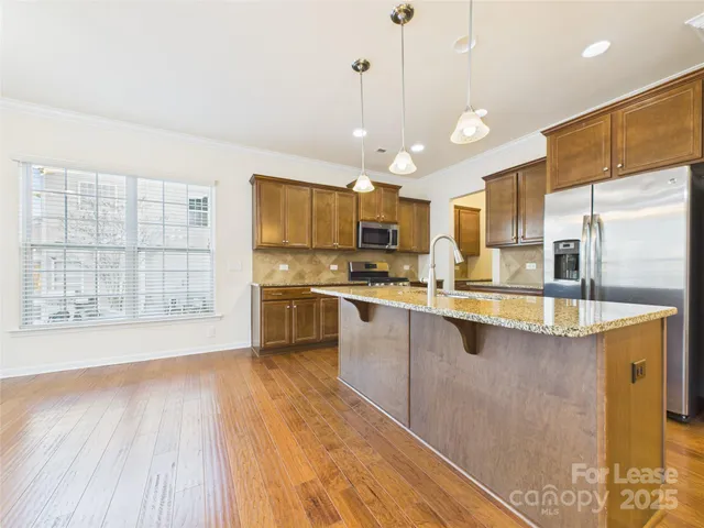 a large kitchen with kitchen island a large counter space a sink appliances and cabinets