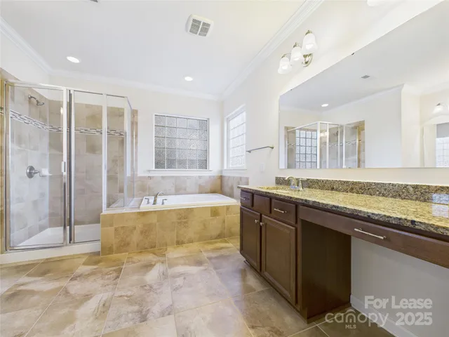 a large bathroom with a granite countertop tub sink and mirror