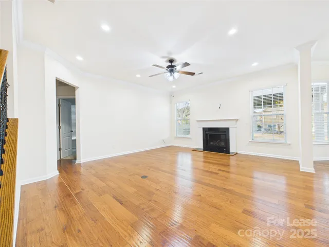 a view of empty room with wooden floor and fireplace