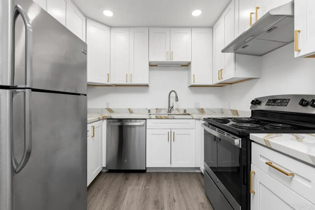 889 Bracero Road Encinitas, CA 92024 - Photo 38 of 59 a kitchen with stainless steel appliances granite countertop a refrigerator a sink dishwasher a stove and white countertops with wooden floor