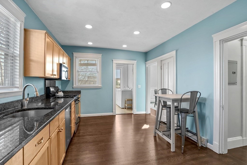 12 Clover Street, Unit 2 Boston, MA 02122 - Photo 5 of 13 a kitchen with granite countertop a sink chairs and wooden floor