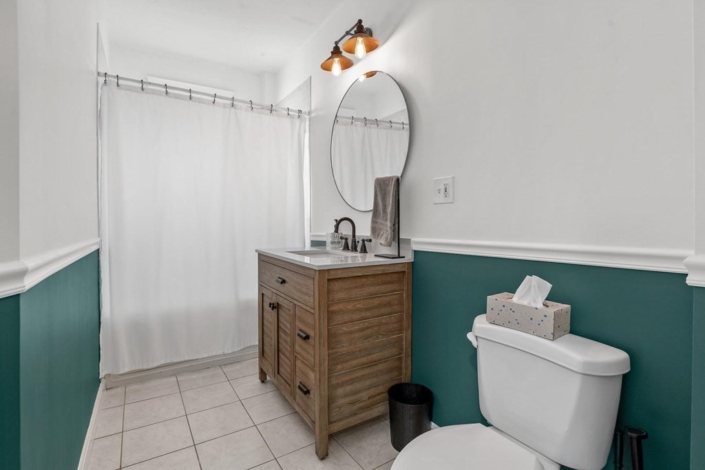 12 Clover Street, Unit 2 Boston, MA 02122 - Photo 9 of 13 a bathroom with a toilet sink and mirror