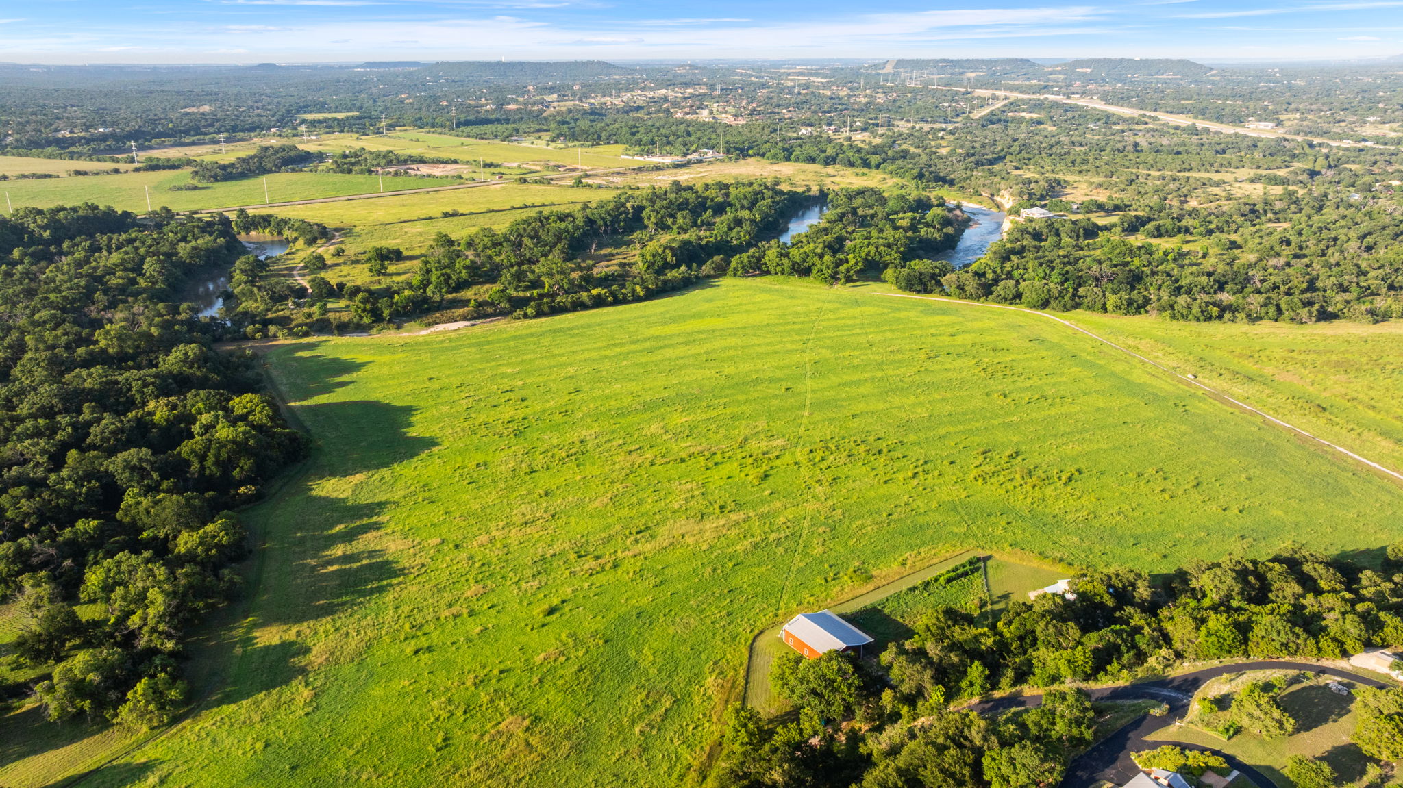1427 River Ridge Ranch Road Killeen, TX 76549 - Photo 36 of 40 Vast green acreage unfolds with a winding river and dense woodlands bordering the property.